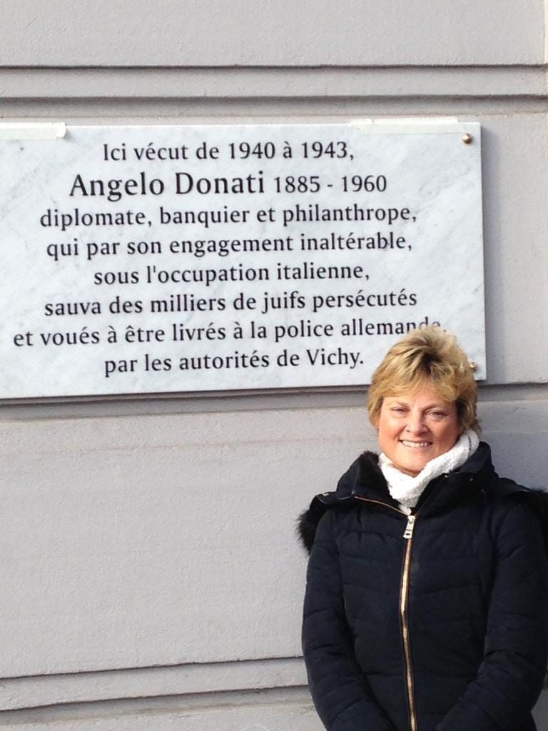 Claudia De Benedetti in front of a memorial plaque on the house in which Angelo Donati lived in Nice, France, in 1940-1943